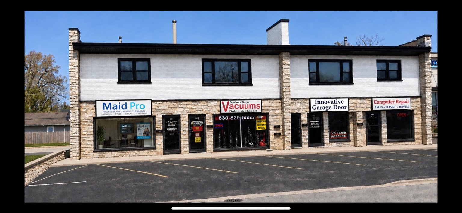 Exterior of 650 Ogden Avenue in Downers Grove, showing its commercial storefronts and upper-floor residential space